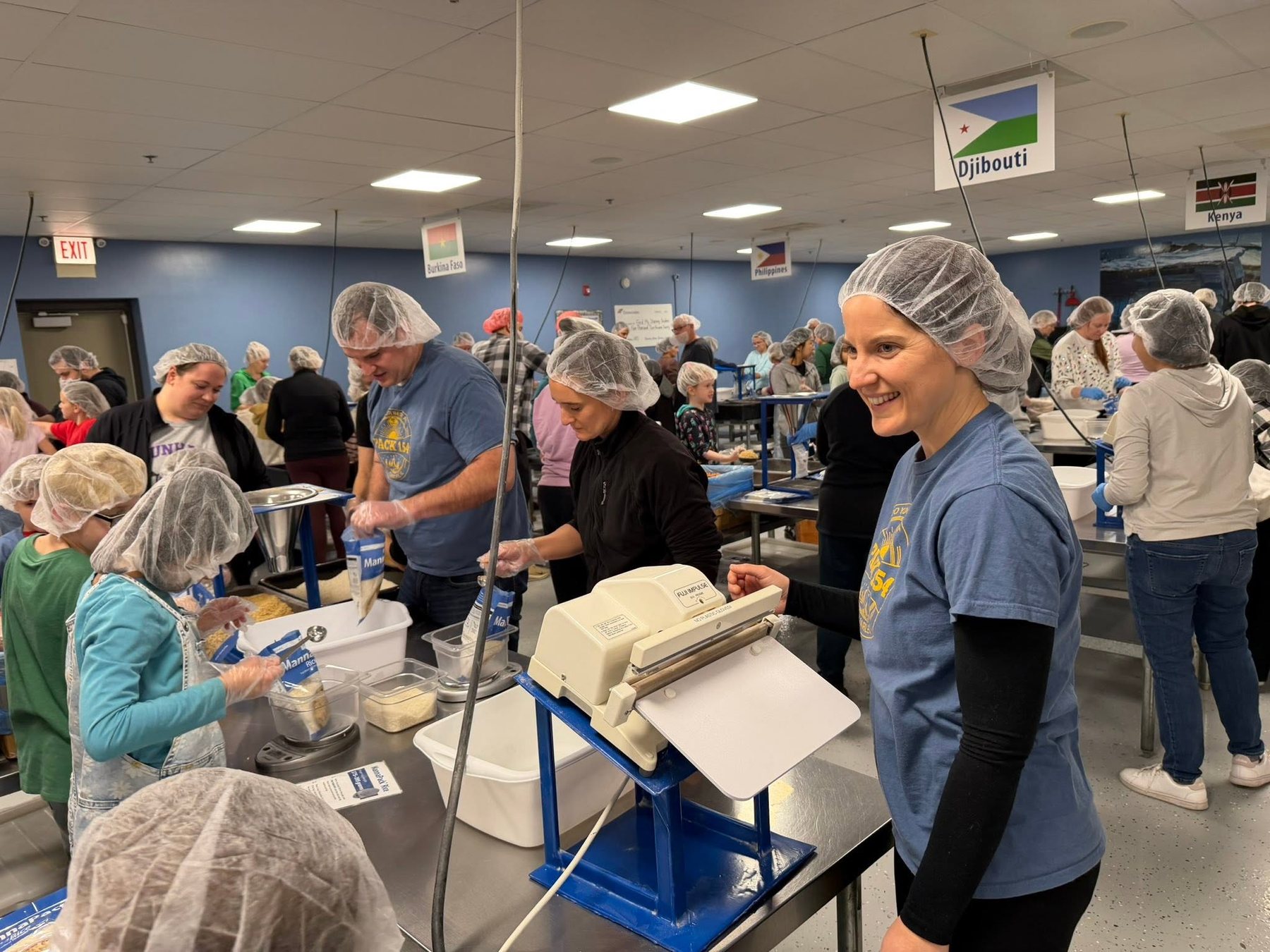 Pack 154 children and parents serving together at a community food-packing event